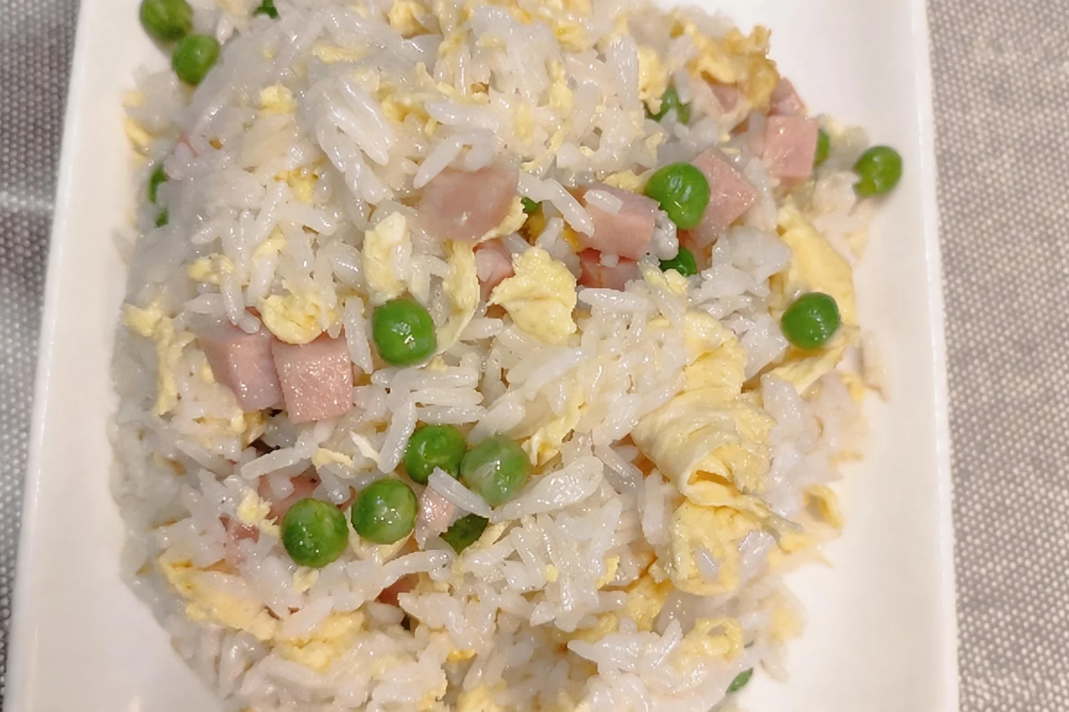 77 Cantonese fried rice, white rectangular plate, grey placemat