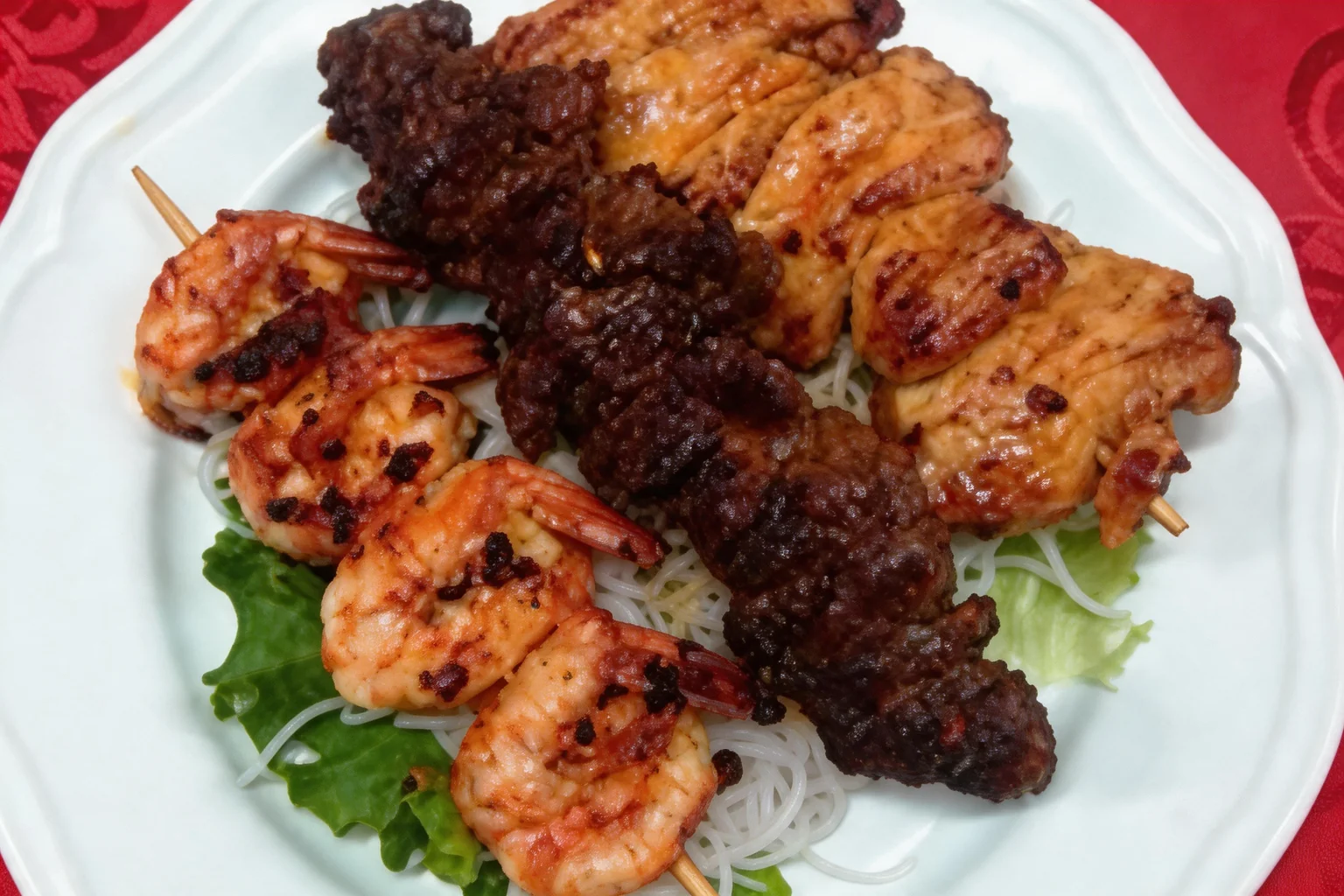 A6 Assorted skewers, white plate, red tablecloth